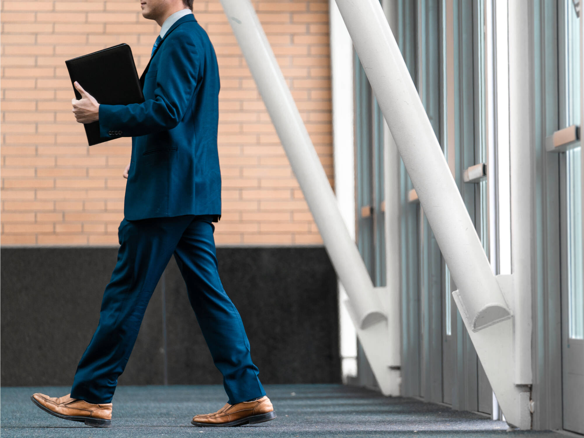 Student in a suit walking with their resume